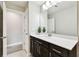 An open bathroom with quartz countertops, dark wood cabinets and a door leading to another room at 6700 Devlin Ln, Wesley Chapel, FL 33545