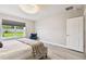 Charming bedroom featuring backyard views, a comfortable bed, and a decorative accent chair at 6700 Devlin Ln, Wesley Chapel, FL 33545