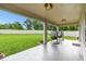 Outdoor patio featuring two modern hanging chairs and views of the lush green backyard at 6700 Devlin Ln, Wesley Chapel, FL 33545