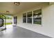 Covered outdoor patio with sliding glass doors and recessed lighting overlooking the backyard at 6700 Devlin Ln, Wesley Chapel, FL 33545