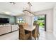 Comfortable dining space with a wooden table, stylish lighting, and access to the outdoor patio at 6700 Devlin Ln, Wesley Chapel, FL 33545