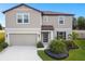 Charming two-story home with a well-manicured lawn, attached garage, and lovely landscaping at 6700 Devlin Ln, Wesley Chapel, FL 33545