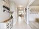 Well-lit hallway with decorative accents, neutral color palette, and tiled flooring at 6700 Devlin Ln, Wesley Chapel, FL 33545
