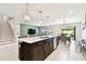 Bright, modern kitchen with a large island, stainless steel appliances, and an adjacent dining area at 6700 Devlin Ln, Wesley Chapel, FL 33545