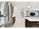 Bright kitchen with a stainless steel refrigerator, dark cabinets, and a center island with seating at 6700 Devlin Ln, Wesley Chapel, FL 33545