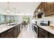 Elegant kitchen boasts granite countertops, stainless appliances, dark wood cabinetry, and bar stool seating at 6700 Devlin Ln, Wesley Chapel, FL 33545