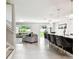 Open floor plan featuring a modern kitchen with bar seating and a spacious living room with a large window at 6700 Devlin Ln, Wesley Chapel, FL 33545