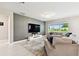 Relaxing living room offers a comfortable sectional sofa, mounted TV, and serene backyard views at 6700 Devlin Ln, Wesley Chapel, FL 33545
