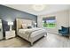 Elegant main bedroom with a decorative wall, comfortable bed, and serene backyard views at 6700 Devlin Ln, Wesley Chapel, FL 33545