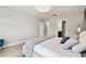 Bright main bedroom featuring a decorative light fixture, comfortable bed, and access to the bathroom at 6700 Devlin Ln, Wesley Chapel, FL 33545