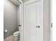 Powder room features a toilet and grey wall at 6700 Devlin Ln, Wesley Chapel, FL 33545