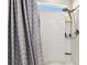 Shower includes grey chevron curtain and sleek shower head and shelf with product at 6700 Devlin Ln, Wesley Chapel, FL 33545