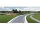 Community entrance featuring stone signage and windwill surrounded by mature trees and lush landscaping at 6759 Michael Favor Way, Wesley Chapel, FL 33545