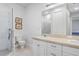 Bright bathroom featuring tiled shower, white vanity with double sinks, and decorative wall art at 6823 S Kissimmee St, Tampa, FL 33616