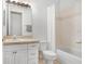 Bathroom with shower and tub combo, white cabinet and beige countertops at 6823 S Kissimmee St, Tampa, FL 33616