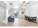 Open-concept living and dining area boasting wood floors, fan, and sliding glass doors to a balcony at 6823 S Kissimmee St, Tampa, FL 33616