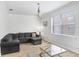 Light-filled living room with wood floors, neutral paint and comfortable sectional sofa with ottoman at 6823 S Kissimmee St, Tampa, FL 33616