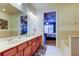 Bathroom with double vanity, cherry cabinets, and neutral tile at 7903 Seminole Blvd # 2103, Seminole, FL 33772