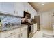 Modern kitchen with stainless steel appliances, white cabinets, and marble countertops at 7903 Seminole Blvd # 2103, Seminole, FL 33772