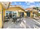 Waterfront outdoor patio, with dining set, and sliding glass doors, next to lush tropical landscaping at 8014 12Th S Ave, St Petersburg, FL 33707