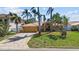 Charming home with a beautiful lawn, terracotta roof, palm trees, and a paved driveway, perfect for coastal living at 8014 12Th S Ave, St Petersburg, FL 33707