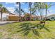 Charming single-story home with a tile roof and a well-manicured lawn and palm trees at 8014 12Th S Ave, St Petersburg, FL 33707