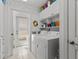 Functional laundry room with white appliances, cabinets, and access to the exterior at 8014 12Th S Ave, St Petersburg, FL 33707
