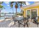 Outdoor patio with waterfront views, featuring a dining table and seating area, with lush tropical landscaping at 8014 12Th S Ave, St Petersburg, FL 33707