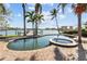 Backyard with a pool, spa, and water views, featuring lush tropical landscaping at 8014 12Th S Ave, St Petersburg, FL 33707