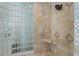 Detailed view of the shower area with glass block wall, tile accents, built-in seat, and shower head at 8014 12Th S Ave, St Petersburg, FL 33707