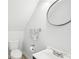 Small but functional bathroom features toilet, sink, a modern round mirror, and toilet paper holder at 8439 Boxwood Dr, Tampa, FL 33615