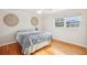 Bedroom with hardwood floors, ceiling fan, neutral walls, and natural light from a large window at 8439 Boxwood Dr, Tampa, FL 33615