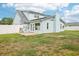 Exterior showcasing a light blue house with a well-maintained lawn and a black metal roof at 8439 Boxwood Dr, Tampa, FL 33615