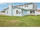 Exterior view of a light blue two-story home with a dark metal roof and green lawn at 8439 Boxwood Dr, Tampa, FL 33615