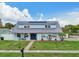 Charming blue two-story home featuring a metal roof, solar panels, and well-manicured lawn at 8439 Boxwood Dr, Tampa, FL 33615