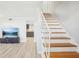 Bright living room features newly finished wood stairs, light wood-like floors, and fresh paint at 8439 Boxwood Dr, Tampa, FL 33615