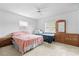 Bright bedroom featuring two beds, neutral carpet, a ceiling fan, and natural light from a large window at 9069 Gaynor St, Spring Hill, FL 34608