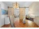 Dining room with barn doors, rustic light fixture and view of living area at 9069 Gaynor St, Spring Hill, FL 34608