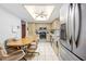 Eat-in kitchen with natural wood cabinets, white tile floors, stainless steel refrigerator, and modern appliances at 9069 Gaynor St, Spring Hill, FL 34608