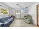 Bright living room with large windows, ceiling fan, and wood-look flooring at 9069 Gaynor St, Spring Hill, FL 34608