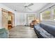 Living room featuring wood-look flooring, large windows, barn door and comfortable seating at 9069 Gaynor St, Spring Hill, FL 34608