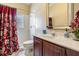 Well-lit bathroom with stylish vanity, mirror, and shower with patterned curtain at 10003 Vista Pointe Dr, Tampa, FL 33635