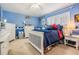 Serene blue bedroom featuring natural light, carpeted floors, ample closet space, and classic bedroom furniture at 10003 Vista Pointe Dr, Tampa, FL 33635