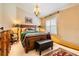 Cozy bedroom with a decorative chandelier, large bed, and a window with white shutters at 10003 Vista Pointe Dr, Tampa, FL 33635