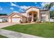 Spacious two-story home featuring a manicured lawn, attached three-car garage, and welcoming front entrance at 10003 Vista Pointe Dr, Tampa, FL 33635
