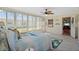 Bright bedroom with large windows, a tropical-themed ceiling fan, and a glimpse into an adjacent room at 10155 36Th N Way, Pinellas Park, FL 33782