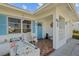 Inviting covered porch with tiled flooring, white lattice accents, and a blue front door at 10155 36Th N Way, Pinellas Park, FL 33782