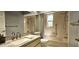 Well-lit bathroom with a shower and tub combination and neutral tile at 10728 Fallen Leaf Ln, Port Richey, FL 34668