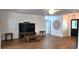 Open living room with wood-look tile floors, modern ceiling fan and entertainment center at 10728 Fallen Leaf Ln, Port Richey, FL 34668