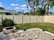 Private fenced backyard featuring a brick paver patio with a stone fire pit and tropical landscaping at 11241 Temple Ct, Seminole, FL 33772
